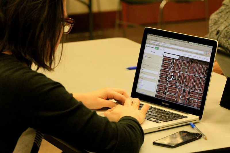 a person working on a laptop computer, editing OpenStreetMap data